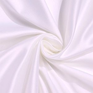 Macro shot of white satin fabric with elegant spiral draping and silky texture
