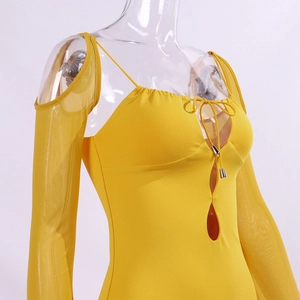 Detail of yellow halter neck dress with cutout design and metallic drawstring tips