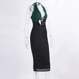 Détail de robe à paillettes vert émeraude avec chaîne dorée et découpe au col
