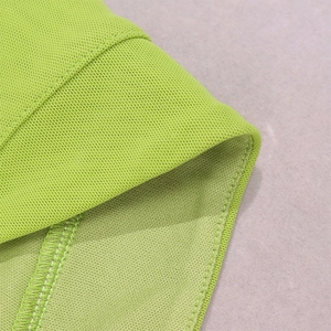 Macro shot of lime green mesh fabric showing high-quality stitching and seam detail