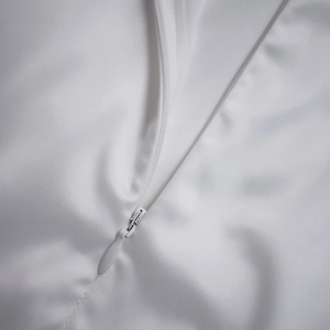 Detail view of the high-quality hidden zipper on a white satin dress with smooth texture