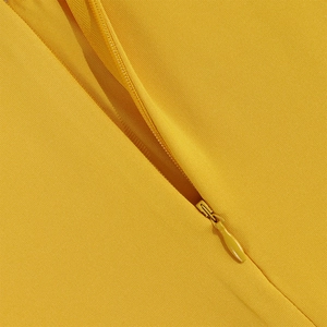 Detail of a bright yellow slim-fit dress showing high-quality invisible zipper and knit fabric