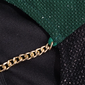 Détail du tissu en maille à paillettes vert foncé avec chaîne dorée et maillon métallique