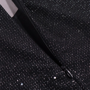 Gros plan d'une fermeture éclair invisible sur une robe noire à paillettes brillantes