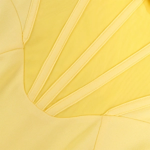 Detail of yellow mesh corset dress showing intricate stitching and sheer paneling