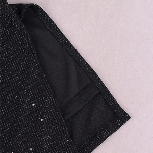 Détail de la robe à paillettes montrant le tissu scintillant et les coutures de précision