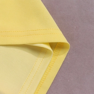 Macro view of yellow fishtail dress hem with reinforced double-stitch sewing detail