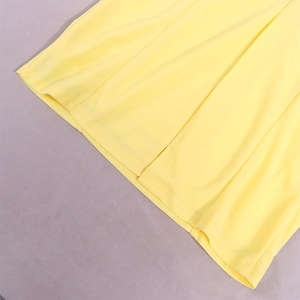 Detail view of double-needle hem stitching on a flowy yellow dress fabric