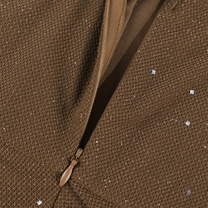 Detailed close-up of invisible zipper and sequined fabric texture on a brown party dress