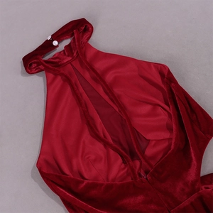 Détail d'une robe en velours bordeaux avec boutons perlés et découpes élégantes