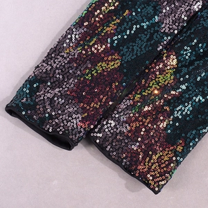 Vue macro détaillée des paillettes multicolores sur la manche d'une robe de Noël