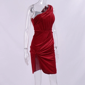Detail of red velvet one-shoulder dress featuring silver sequins and side slit