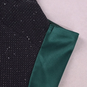 Détail du tissu en maille à paillettes noires cousu avec du satin vert émeraude