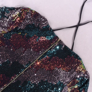 Détail de sequins multicolores sur une robe moulante avec zip doré et bretelle noire
