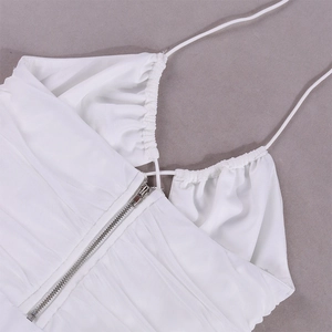 Detail of white corset top with thin straps, ruched neckline and silver metal zipper