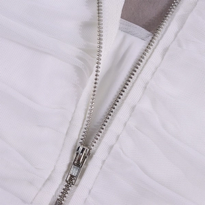 Detail of silver metal zipper on white mesh fabric of a halter neck corset top