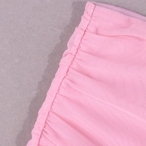 Détail du tissu en maille rose avec des fronces complexes et une texture fine