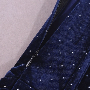Détail de robe en velours bleu foncé avec strass étincelants et fermeture éclair