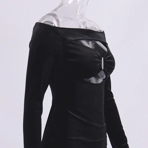 Detalle de vestido ajustado de terciopelo con abertura en pecho y adorno metálico