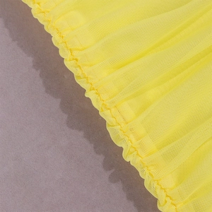 Detail of bright yellow mesh fabric featuring ruched texture and intricate pleated design