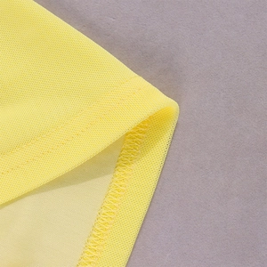 Close-up of bright yellow mesh fabric with reinforced stitching and breathable texture