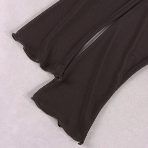 Détail du tissu en maille noire transparente avec bords ondulés et finition à volants