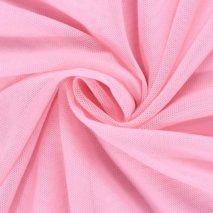 Détail du tissu en maille rose montrant la texture alvéolée fine et les plis superposés