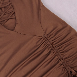 Detail of dark brown dress featuring hollow out lace-up design and ruched fabric texture