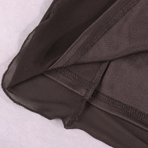Gros plan sur l'ourlet en maille transparente et les coutures d'une robe marron foncé
