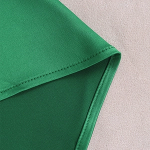 Macro shot of fine stitching and emerald green satin fabric texture on this sexy dress