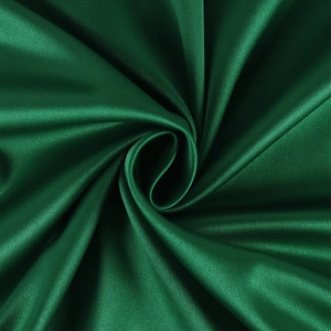 Macro shot of dark green satin fabric showing silky texture and elegant glossy folds