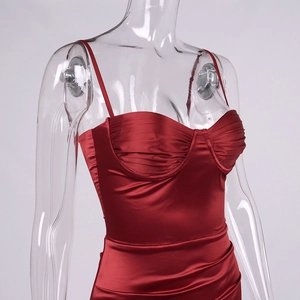 Detail of burgundy satin dress showing ruched bust design and adjustable straps