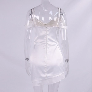 Detail view of white satin slip dress featuring back zipper and asymmetric ruffled hem