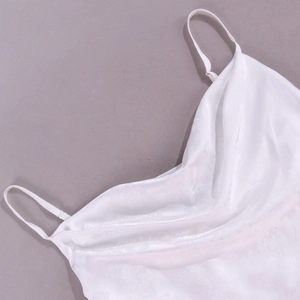Dettaglio dell'abito in raso bianco con scollo a cappuccio e jacquard floreale