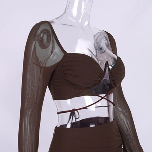 Dettaglio di un set a due pezzi marrone scuro con maniche in mesh e lacci sul top