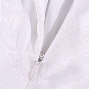 Dettaglio di un abito in raso jacquard bianco con cerniera invisibile e trama floreale