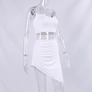 Detailed close-up of white ruched crop top and asymmetrical skirt hemline on a mannequin