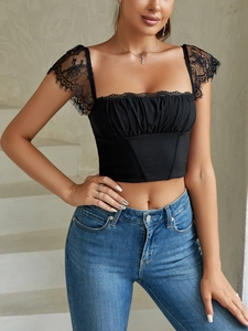 Detail van zwarte kanten crop top met vlindermouwen en vierkante halslijn gedragen door model