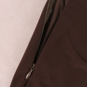 Dettaglio della cerniera nascosta sul tessuto a rete marrone scuro di questo set moda