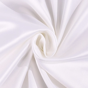 Close-up of white satin fabric showing luxurious glossy texture and elegant drapes