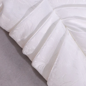 Dettaglio ravvicinato del tessuto in raso jacquard bianco con trama floreale e pieghe