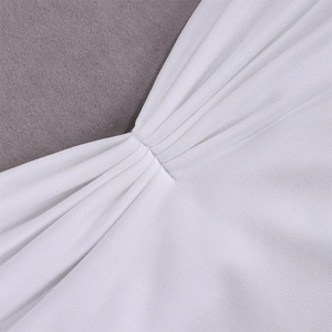 Detailed macro view showing the pleated white fabric and fine knitting texture of the dress