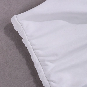 Close-up detail of white ribbed fabric with elegant ruched edges on a stylish two-piece set