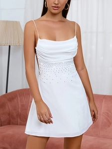 Détail de mini robe en mousseline blanche avec bretelles fines et taille ornée de strass