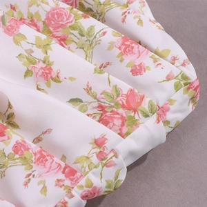 Detailed macro view of the rose floral print and ruffled hem on this summer dress