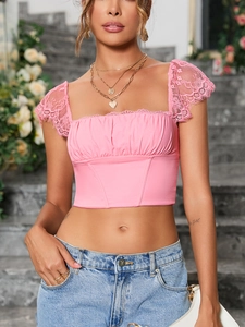 Detail van roze crop top met vierkante hals, delicate kant en korset-stijl stiksels op maat