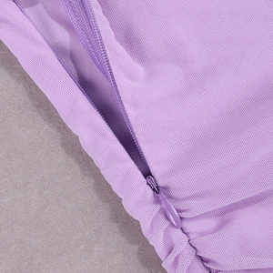 Détail macro de la fermeture éclair invisible sur une robe en maille filet mauve
