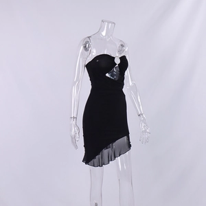Detail of slim fit black mini dress featuring a metal ring cutout and mesh ruffle hem