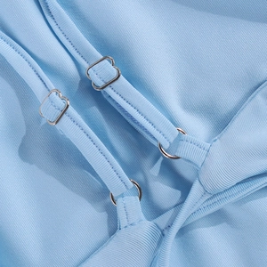 Détail de robe en tissu côtelé bleu ciel avec fines bretelles réglables et boucles argentées