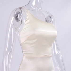 Close-up of champagne satin evening dress showing the one-shoulder design and silky fabric